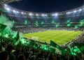 Estádio de futebol lotado à noite em jogo decisivo