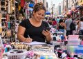 Microempreendedora confere as contas em sua banca no comércio popular do Centro de São Paulo